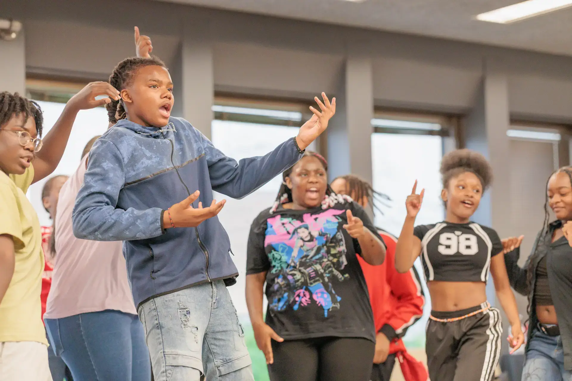 Energetic Black youth perform at Black Arts MKE. Expressive students singing or acting in a dynamic arts program.