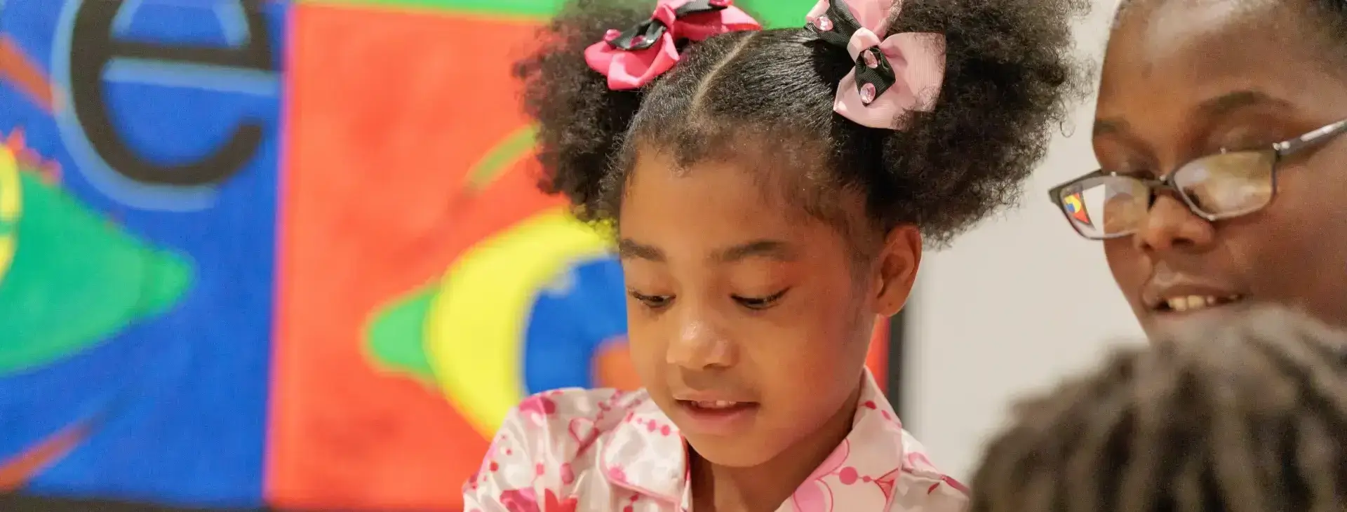 Malaika Early Learning Center student and educator engaged in learning. Urban education initiative.