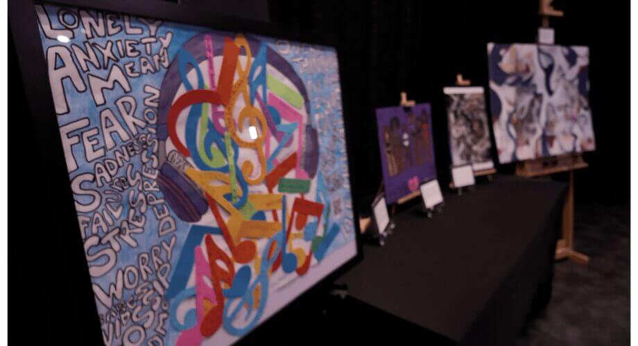 RedGen Art: Music, Emotions & Mental Health Exhibit Expressive artwork at a RedGen exhibit. Features words of anxiety/fear contrasted with vibrant musical notes, symbolizing mental wellness.