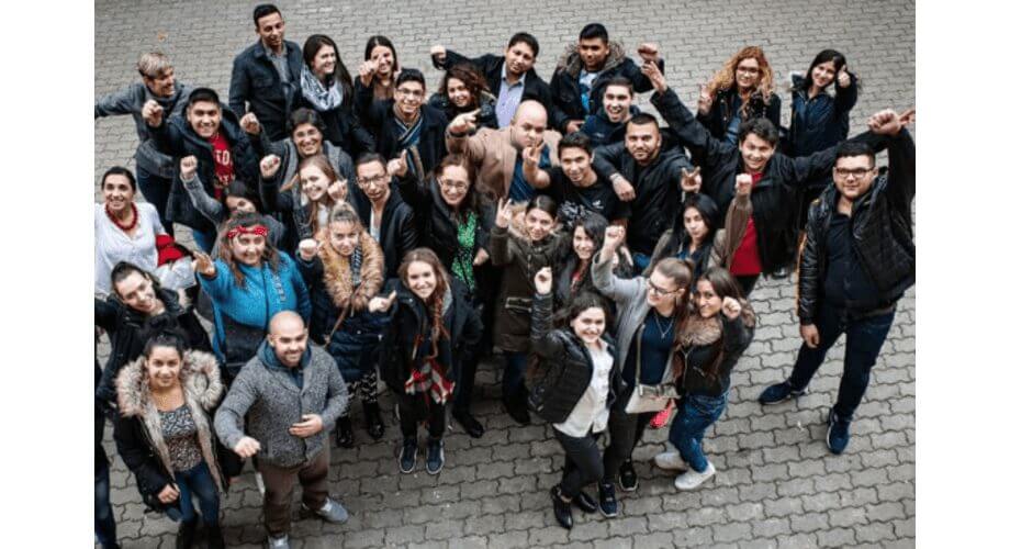 Diverse Youth Group Celebrating Together Overhead view of a large, diverse group of smiling young adults celebrating with raised fists and enthusiastic poses outdoors.