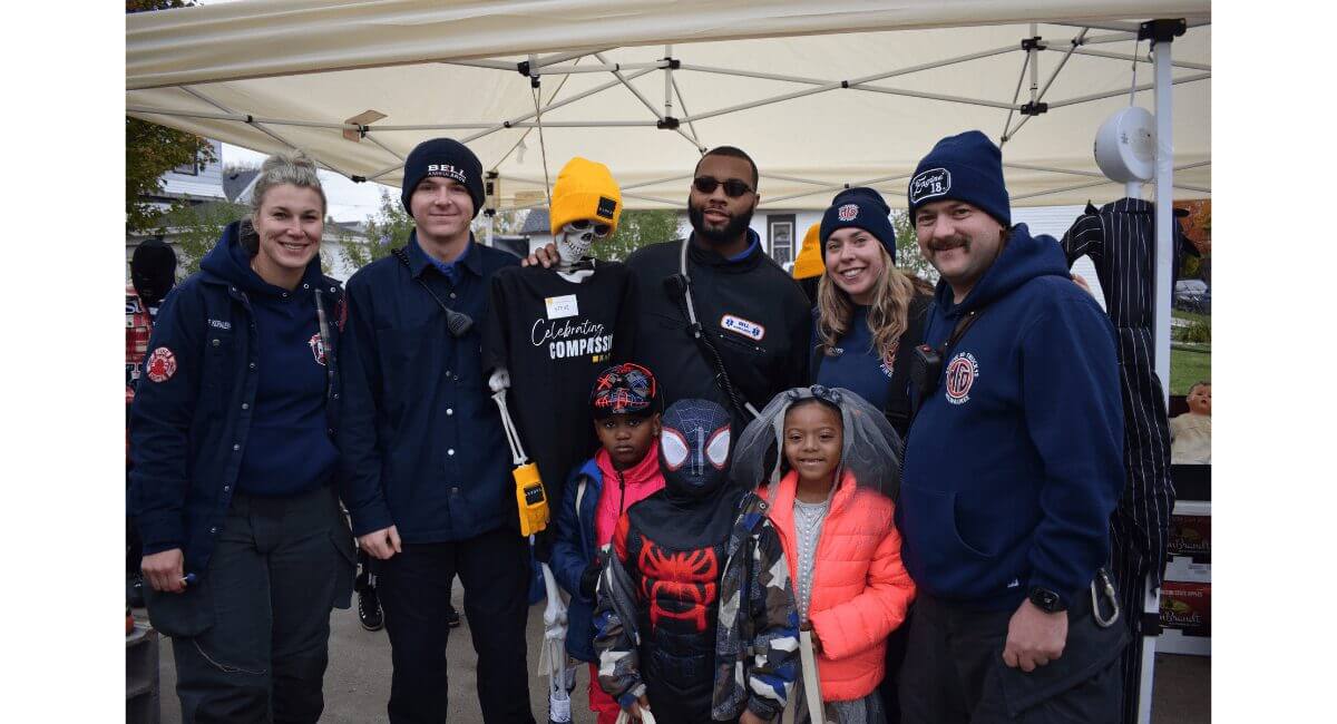 Bell Ambulance and Milwaukee FD first responders with kids in Spider-Man & bridal costumes at a community event.