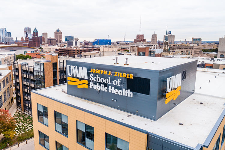 Aerial view of UWM Joseph J. Zilber School of Public Health building. Milwaukee skyline in background.