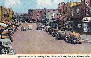Busy Government Road, Kirkland Lake, Ontario, 1926, with vintage cars and historic buildings lining the street.