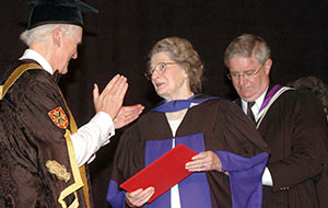 Isabel receives an academic degree or award from a university official during a formal 1995 ceremony.