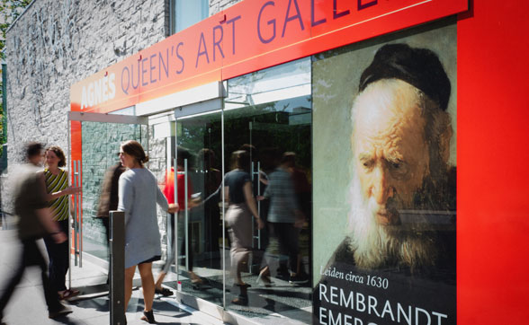 Agnes Queen's Art Gallery entrance, visitors entering. Rembrandt exhibition poster features a historical portrait.'s Art Gallery entrance, visitors entering. Rembrandt exhibition poster features a historical portrait.