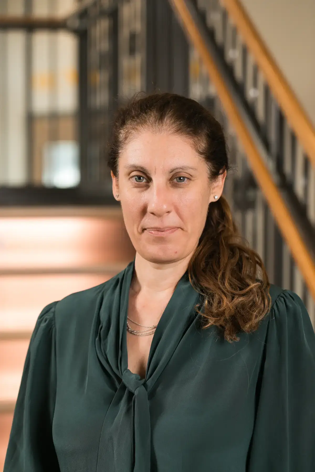 Professional headshot of Adina Shapiro. Woman with dark hair, green blouse, ready for business profiles.
