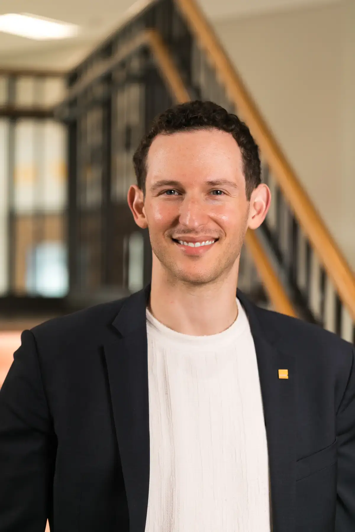 Ben L. Callif smiling professional headshot. Executive portrait in a suit jacket, white shirt, and gold lapel pin.
