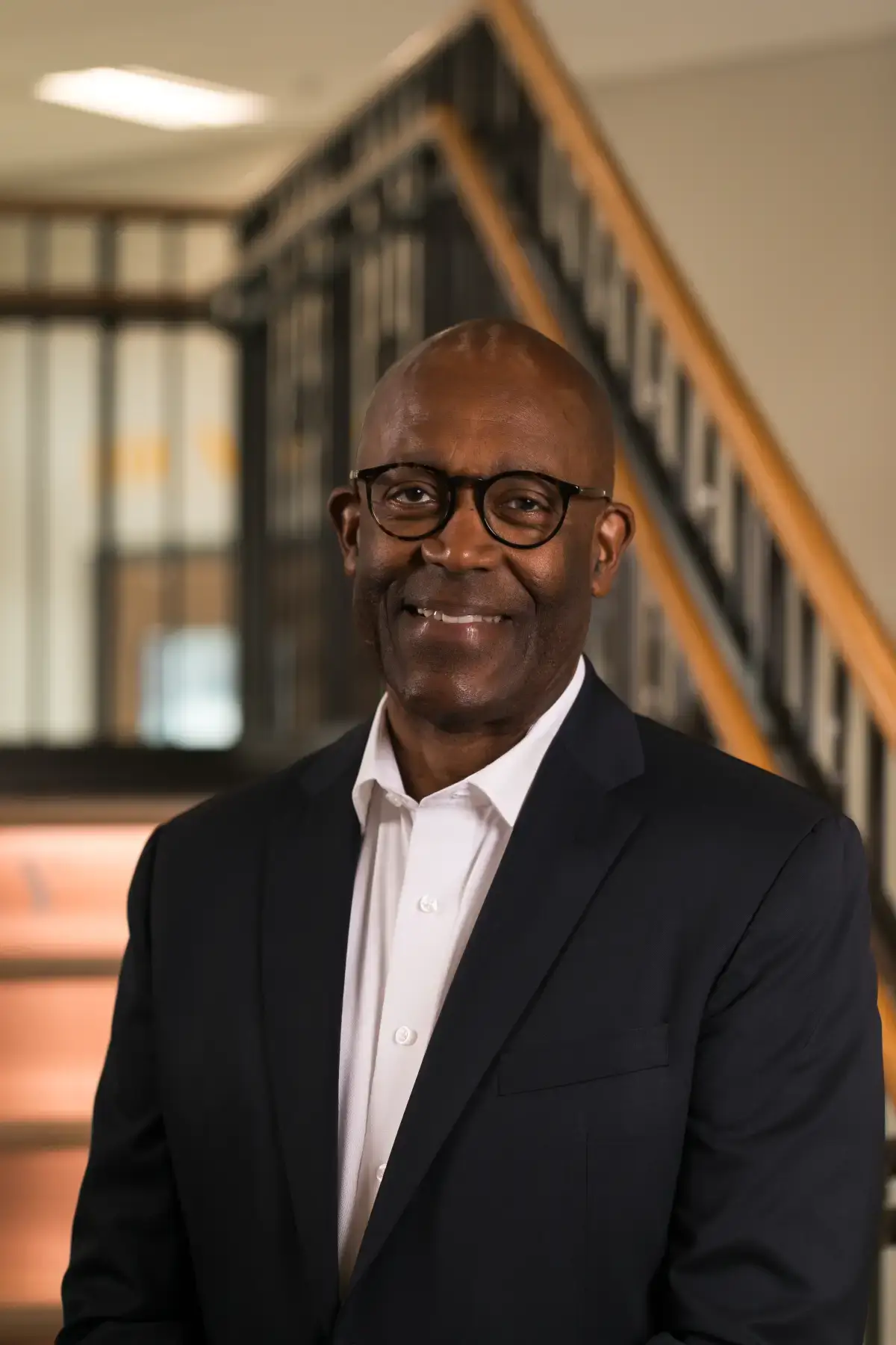 Smiling Franklin E. Cumberbatch in professional headshot. Executive wearing glasses, dark suit, white shirt.