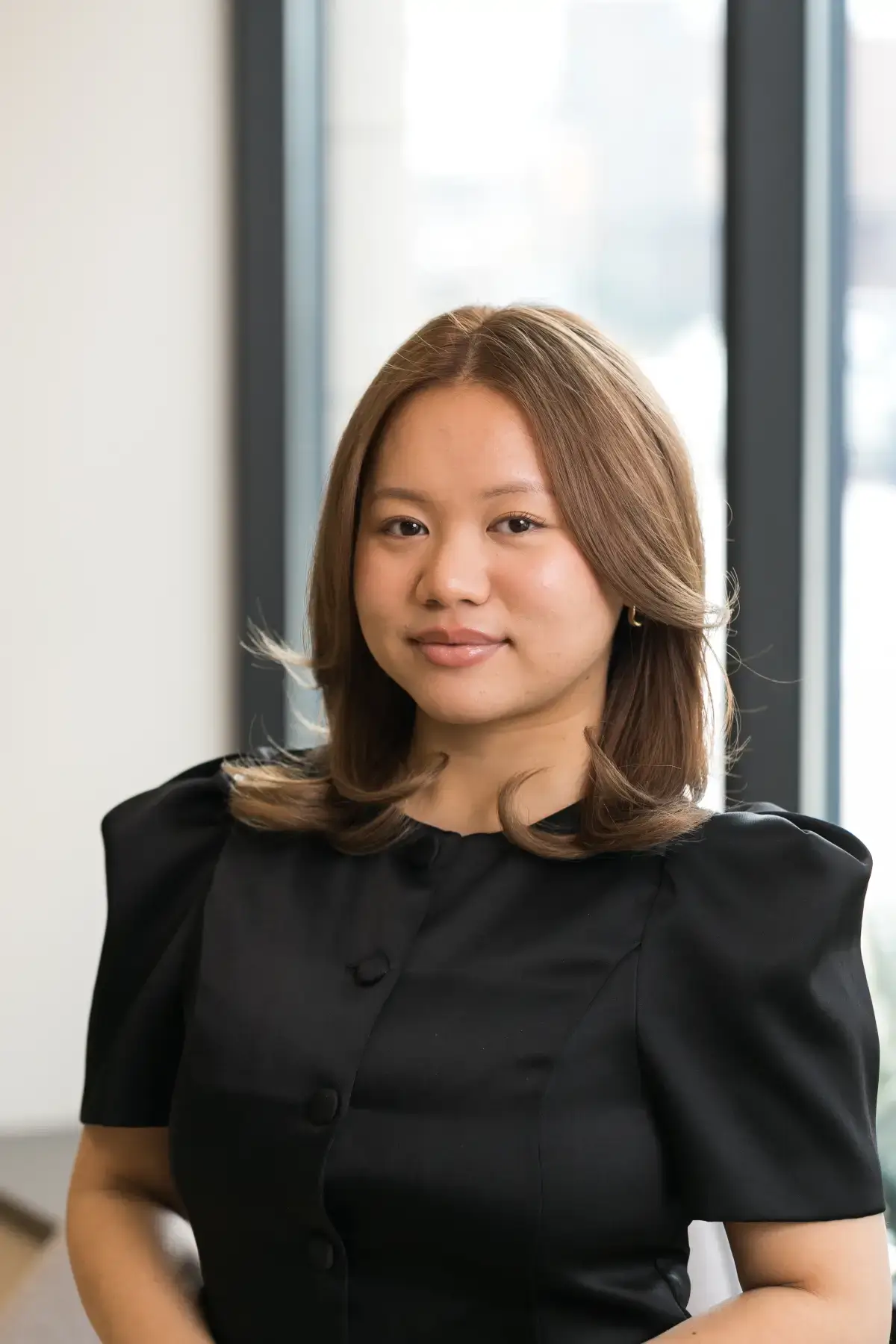 Irene P. Xiong professional headshot. Smiling Asian woman with light brown hair in a black corporate blouse.