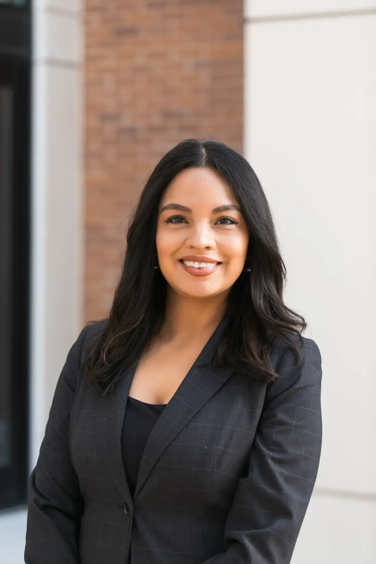 Professional business headshot of Jasmin Treske, smiling woman with dark hair in a dark blazer.