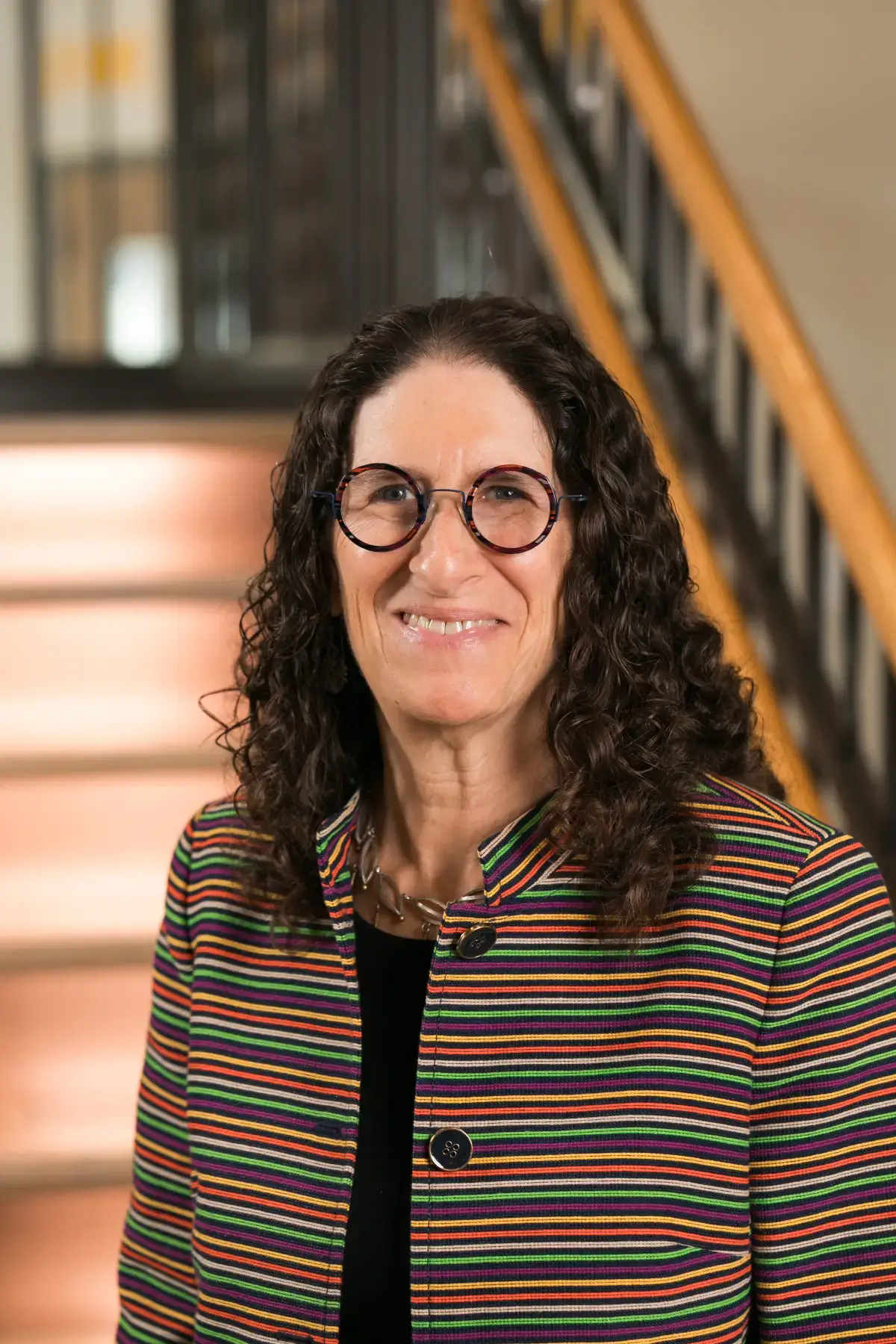 Linda C. Bader smiling professional headshot. She wears glasses and a colorful striped jacket.