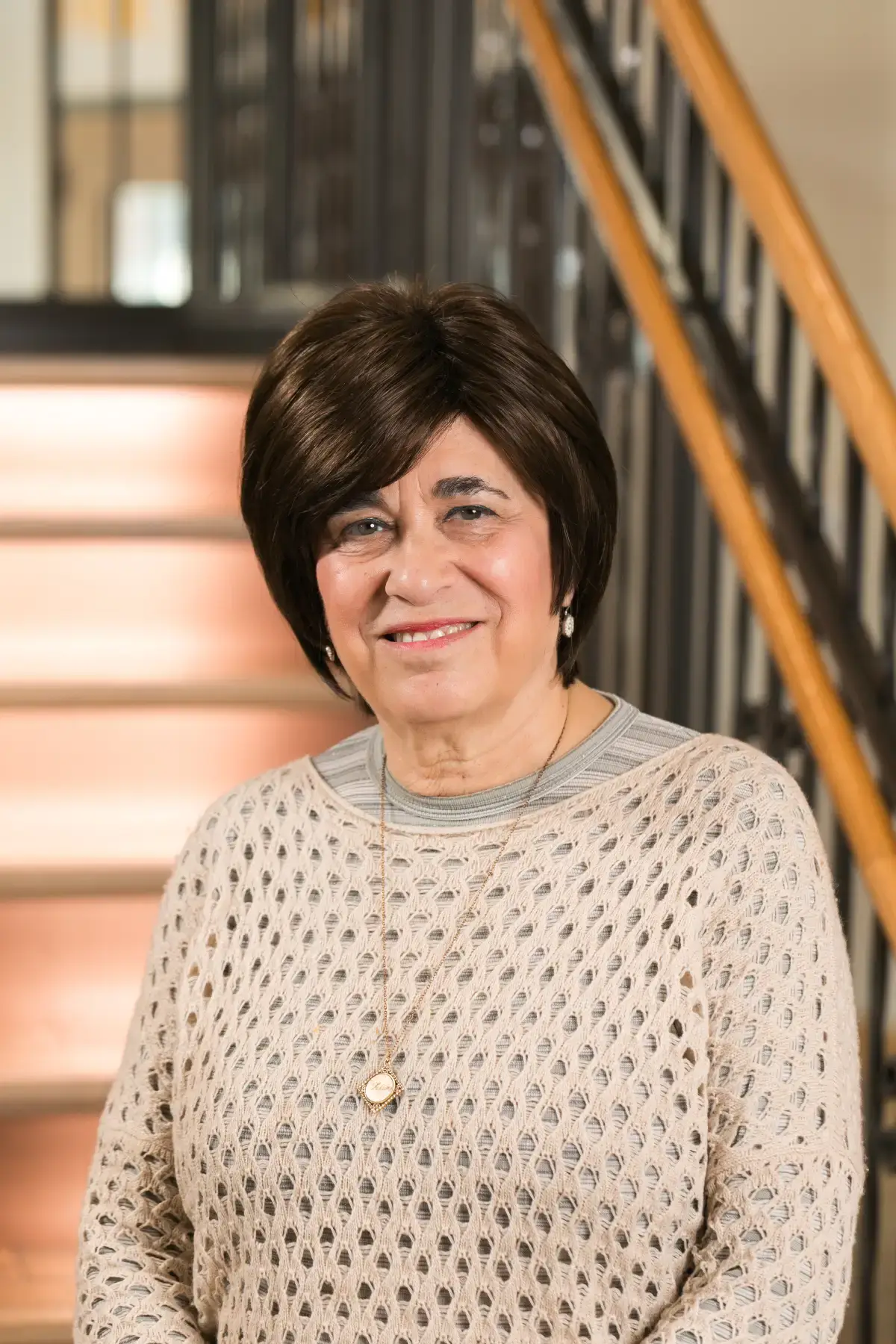 Professional headshot of Lisa Hiller, CEBS, smiling. She wears a light, open-knit sweater with a necklace.