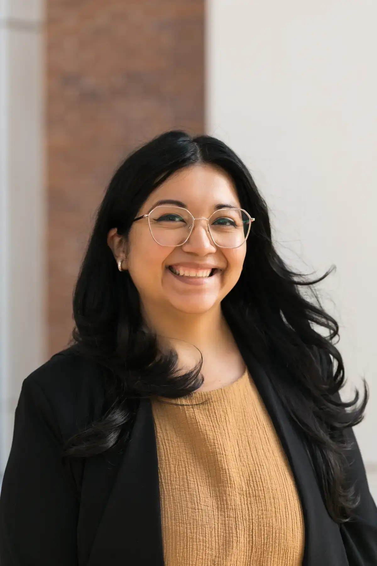 Smiling professional headshot of Sandra Bednarz, a woman with dark hair and glasses in a black blazer.