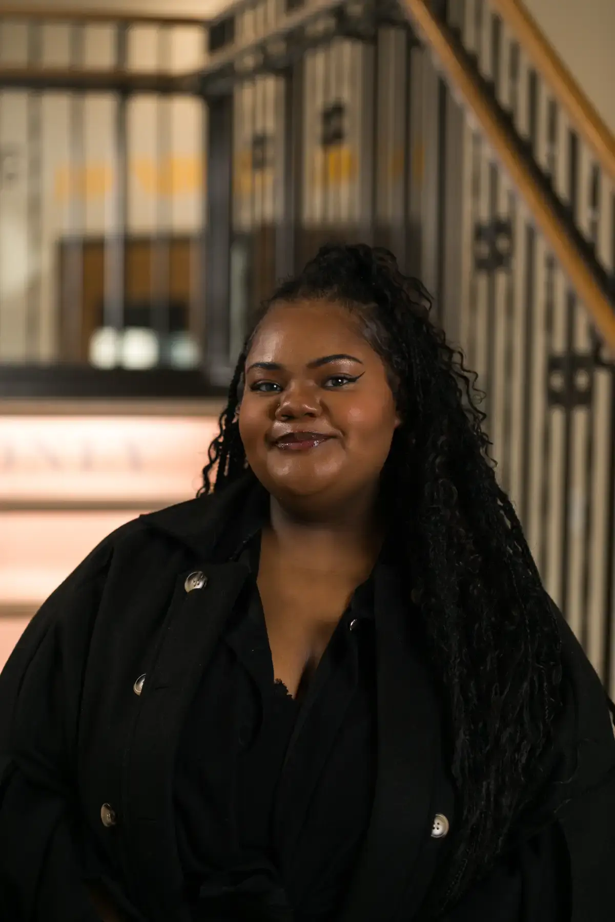 Professional headshot of Taylor Robinson, a smiling Black woman with long dark hair and a black jacket, for business use.