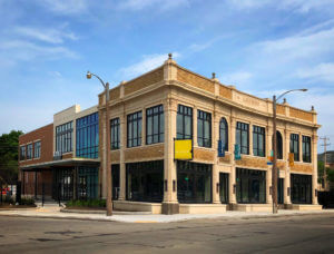 Corner commercial building with modern facade extension and classic brick structure, key for 2018 timeline.