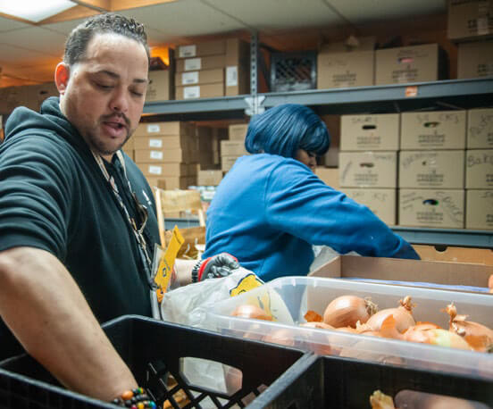 Dedicated volunteers sort fresh onions and produce at Interchange Food Pantry for community distribution.