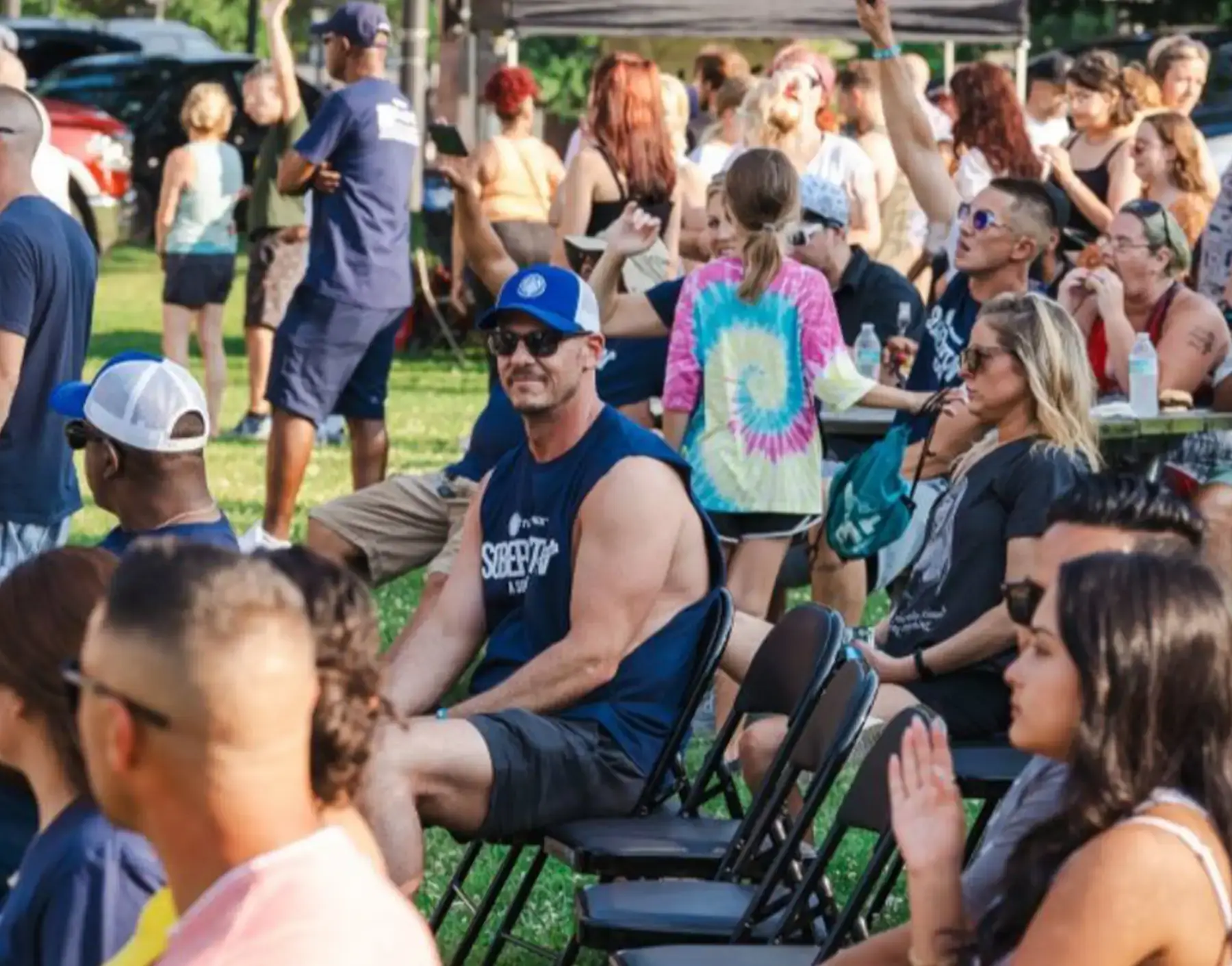 Diverse crowd enjoys Soberfest 2024, an outdoor community event celebrating addiction recovery and sobriety.