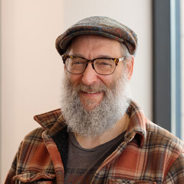 Jonathan Gelfman, a professional man with glasses, beard, and kippah, wearing a suit and shirt.