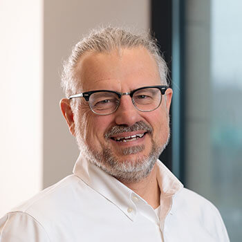 Jonathan Gelfman, a professional man with glasses, beard, and kippah, wearing a suit and shirt.