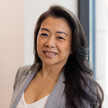 Shary Tran smiling professional headshot, dark hair, navy top, black blazer.